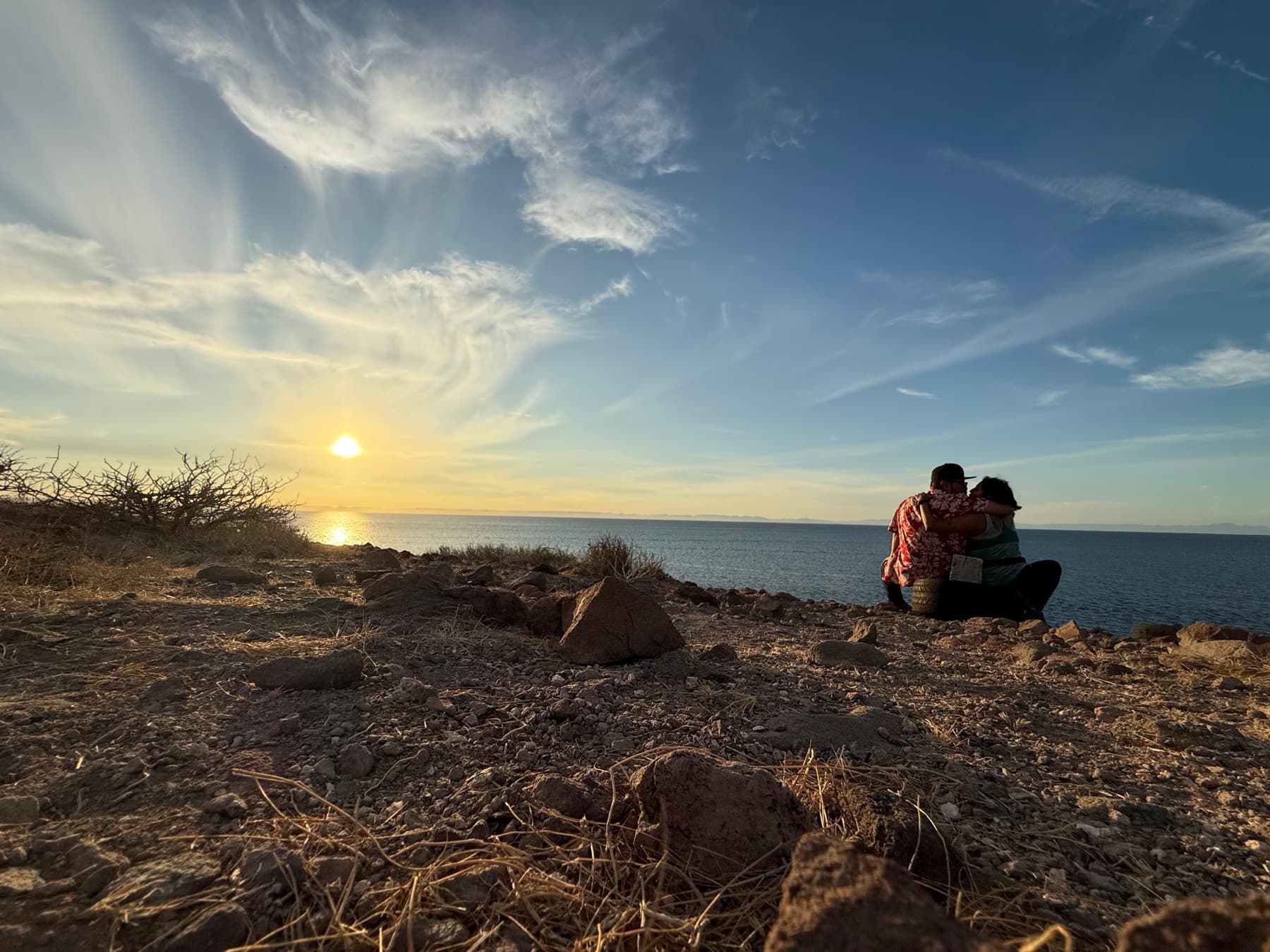 Rosalba y Michael abrazados frente al mar durante el atardecer